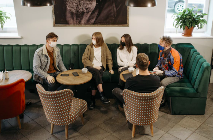 A group of people discussing work at a cafe.